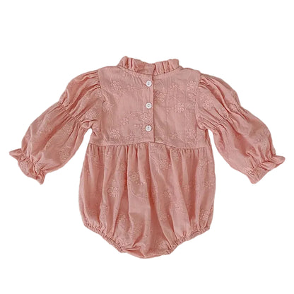 Back view flat lay of a baby girl pink floral embroidered bubble romper showing back button details.