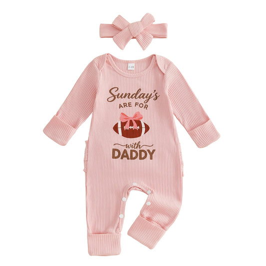 Front view of baby girl pink ribbed long sleeve football romper with "Sundays With Daddy" graphic and matching bow headband on a white background.