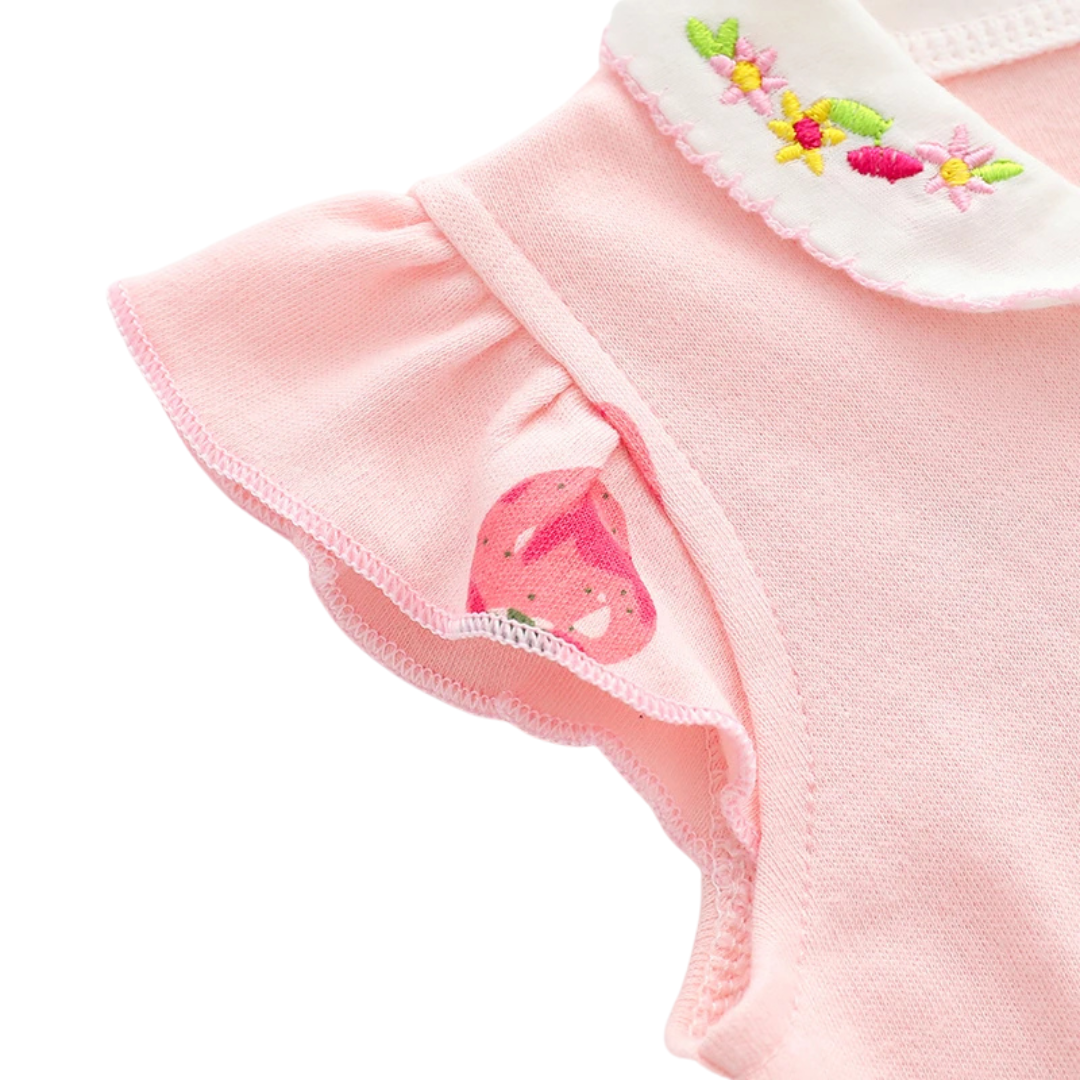 Macro view of the delicate ruffled flutter sleeve on the pink strawberry jumpsuit, highlighting the stitching and pattern detail.