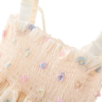 Close-up top view of the elastic smocked bodice and shoulder straps on a baby girl princess dress, highlighting the pastel 3D floral fabric details.