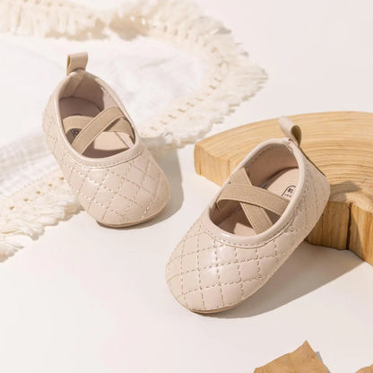 A pair of Kidsely beige quilted baby girl ballet flats arranged on a neutral aesthetic background with wooden props.
