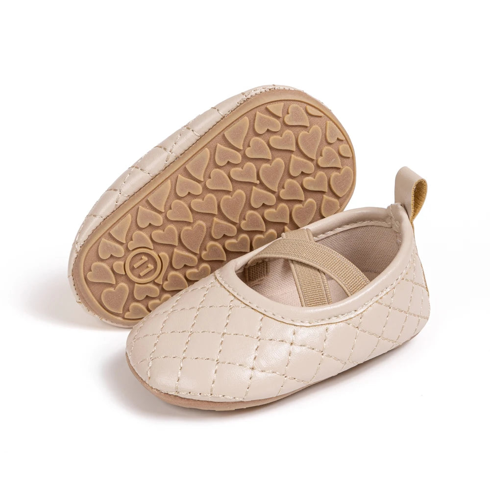 Angle view of a pair of Kidsely beige quilted baby girl Mary Janes, showing the soft non-slip rubber sole.