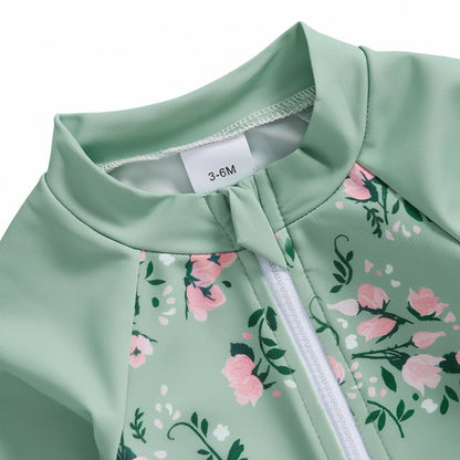 Close-up detail of the front half-zipper on the sage green baby swimsuit featuring a protective fabric chin guard to prevent skin irritation.