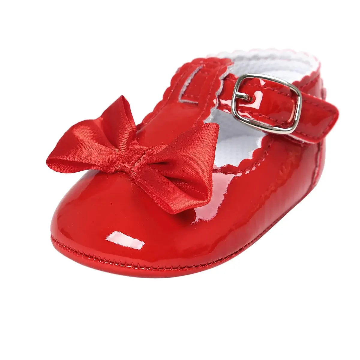 Side angle view of a single baby girl festive red patent leather T-strap holiday dress shoe featuring a matching red satin bow.