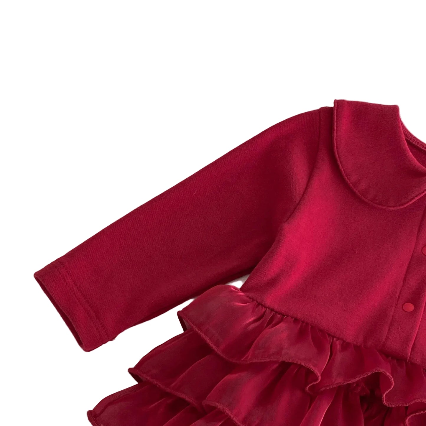 Close-up of the long sleeve and rich red cotton blend fabric of the baby girl festive romper dress.