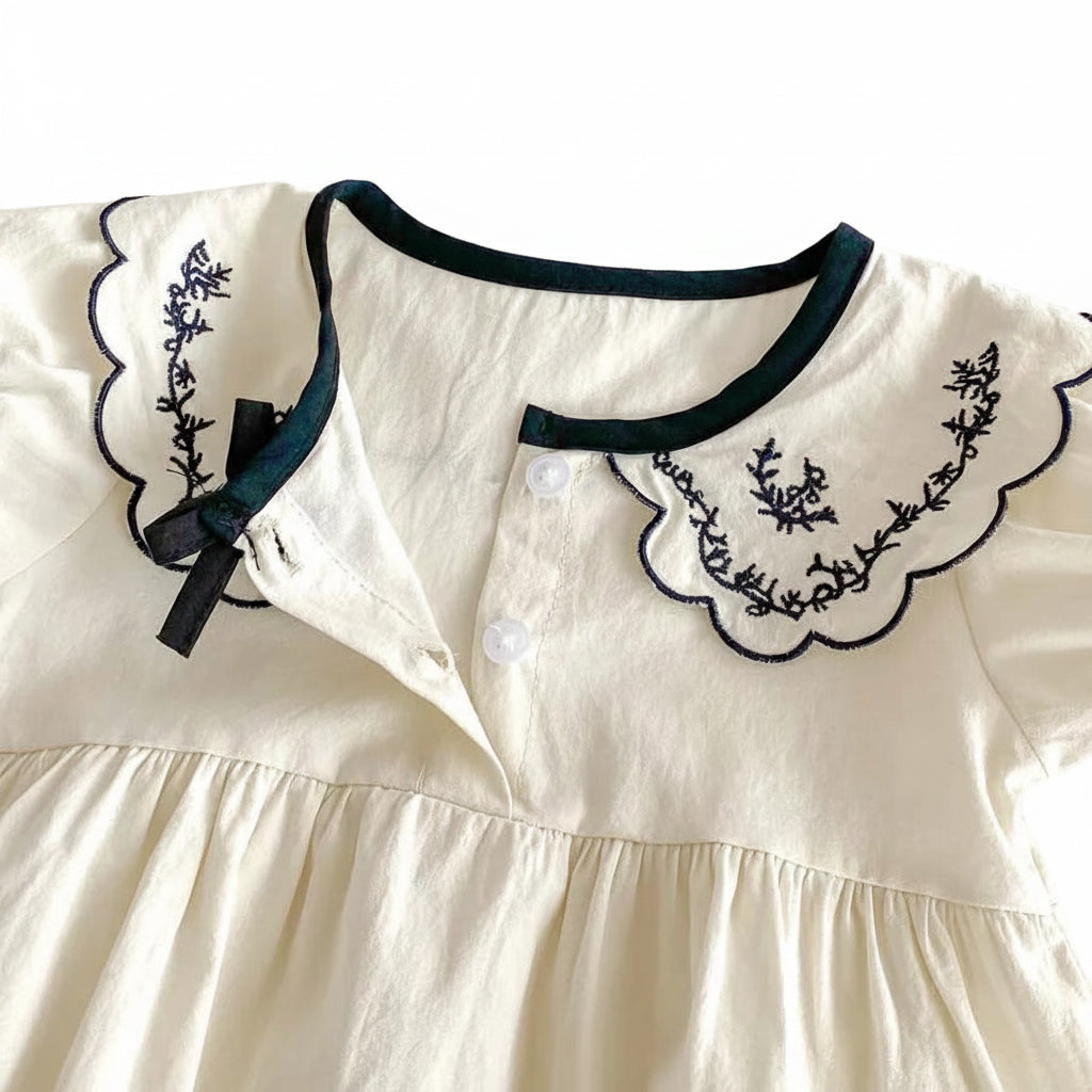 Detail shot of the front button-up closure on the ivory cotton bubble romper for easy dressing.