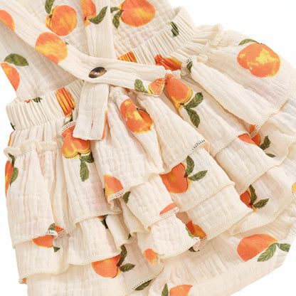 Close-up of the tiered side and back ruffles on the baby peach print romper, highlighting the "ruffle butt" design.