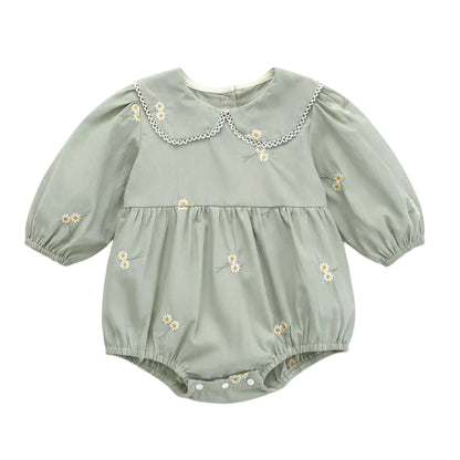 Front flat lay view of a sage green baby girl bubble romper featuring white daisy floral embroidery and a scalloped lace Peter Pan collar.