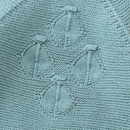 Detailed close-up of the vintage-inspired raised diamond lattice textured knit pattern on the chest of the teal baby romper.