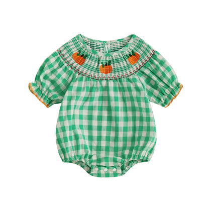 Green smocked gingham baby romper with embroidered pumpkins across the neckline.