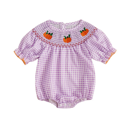 Purple smocked gingham baby romper with embroidered pumpkins across the neckline.