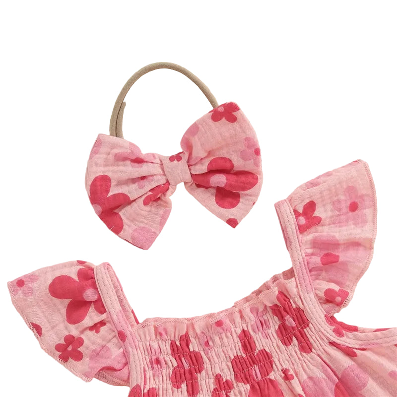 Close-up detail of the pink floral baby girl top showing the stretchy smocked neckline, ruffled fly sleeves, and matching soft elastic bow headband.