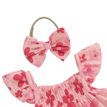 Close-up detail of the pink floral baby girl top showing the stretchy smocked neckline, ruffled fly sleeves, and matching soft elastic bow headband.