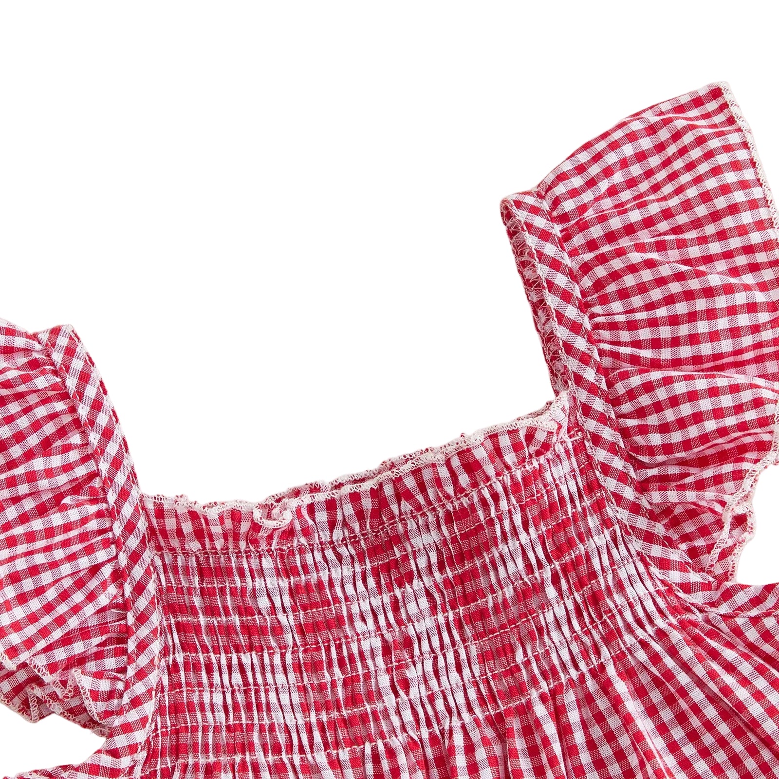 Close-up texture shot highlighting the stretchy elastic shirred smocked bodice and ruffled flutter flying sleeve straps on the red gingham baby top.