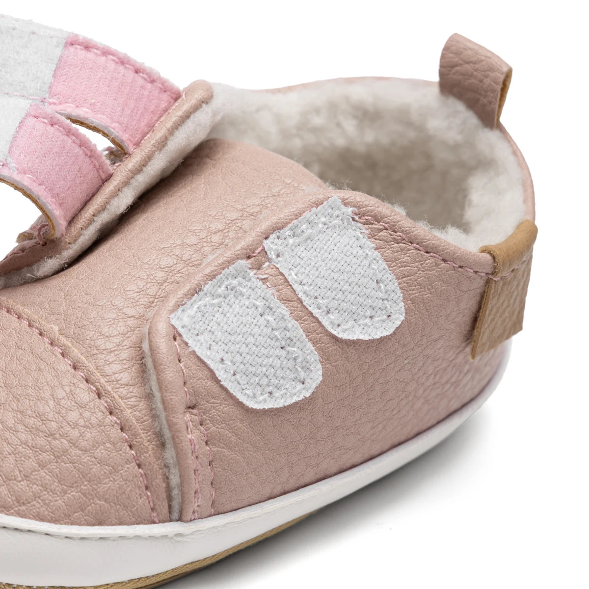 Close-up of the pink infant sneaker with opened hook-and-loop straps demonstrating the easy slip-on, wide-opening design