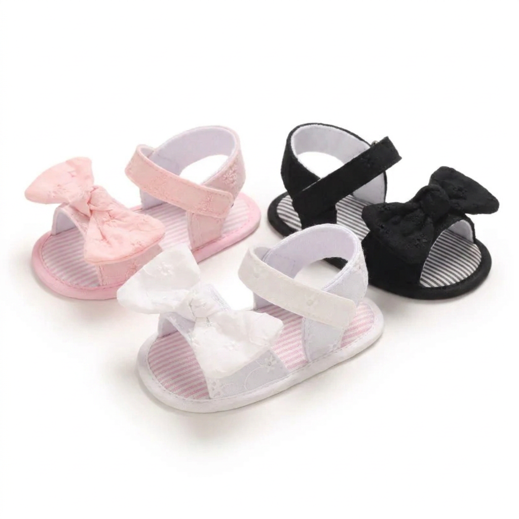 Three pairs of baby girl soft sole bow sandals in pink, white, and black with eyelet lace details.