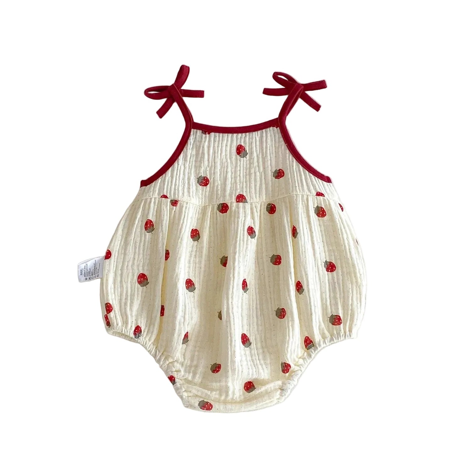 Front view flat lay of the sleeveless cream baby girl strawberry print romper on a solid white surface.