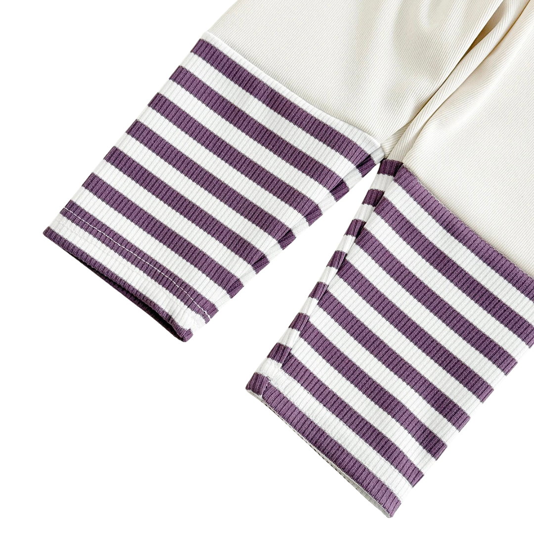 Close-up of purple and white striped rib-knit legging cuffs for toddler girls