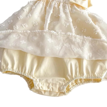 Underside view of the yellow baby romper dress showing the built-in diaper cover and snap fasteners.