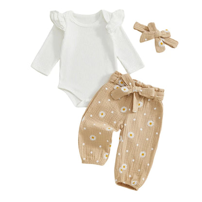 Baby girl 3-piece outfit set in taupe, laid flat to show the white ribbed long-sleeve bodysuit, daisy print pants, and bow headband.