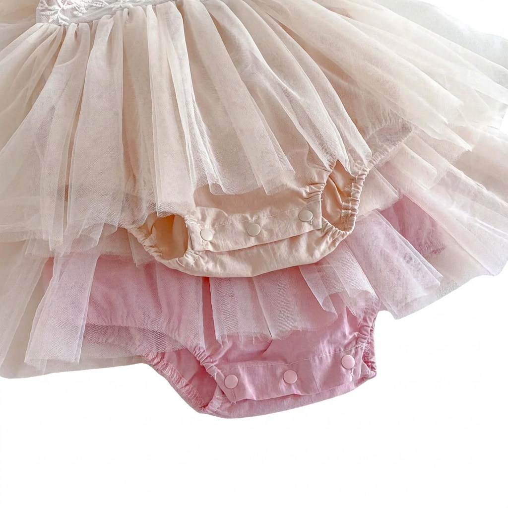 Soft cotton inner lining and snap closure detail under layered tulle baby dress
