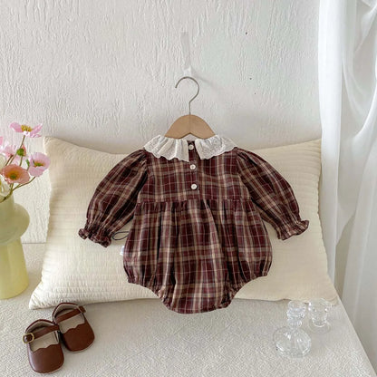 Brown plaid baby girl long sleeve bubble romper hanging on a wooden hanger with matching shoes nearby.