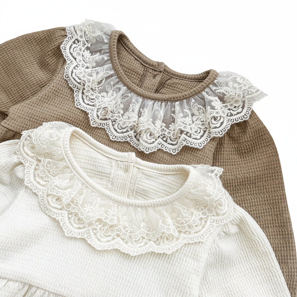 Close-up of mocha brown and cream baby girl waffle knit rompers layered to show off the delicate vintage lace collars.