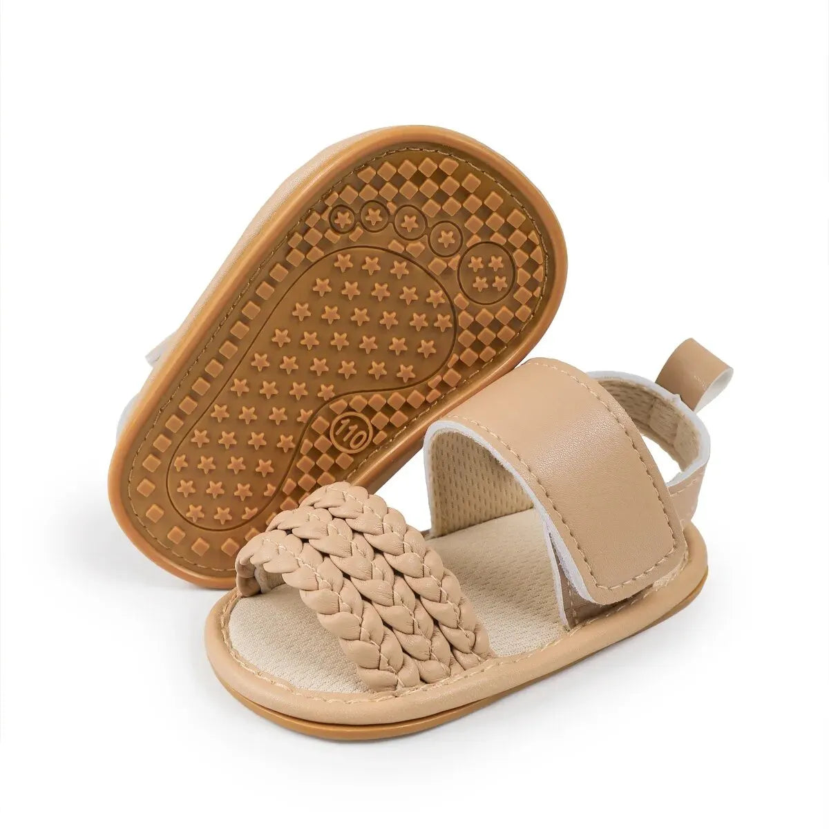 Bottom of a beige baby sandal showing the anti-slip star-textured rubber sole.