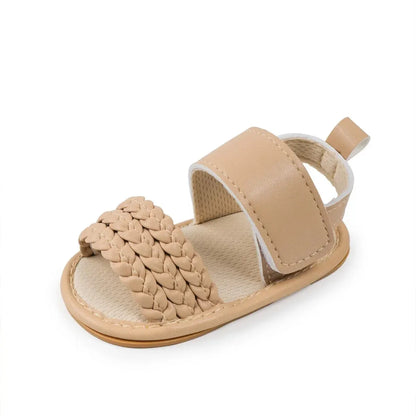 Single beige woven faux leather baby sandal showing the open toe and ankle strap.