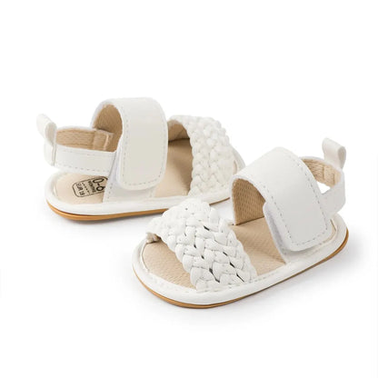 Side profile of white braided strap faux leather baby sandals.
