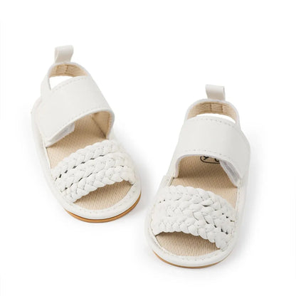 Top-down view of white baby girl woven faux leather sandals with velcro straps.