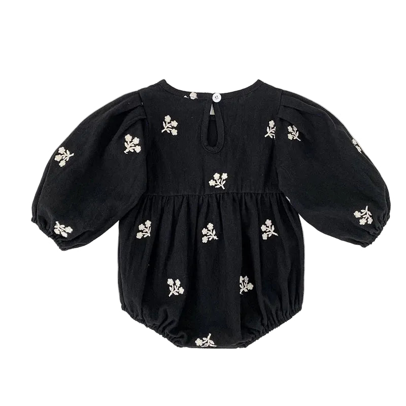 Full back view of the baby girls black floral bubble romper showing the keyhole closure and puff sleeves.