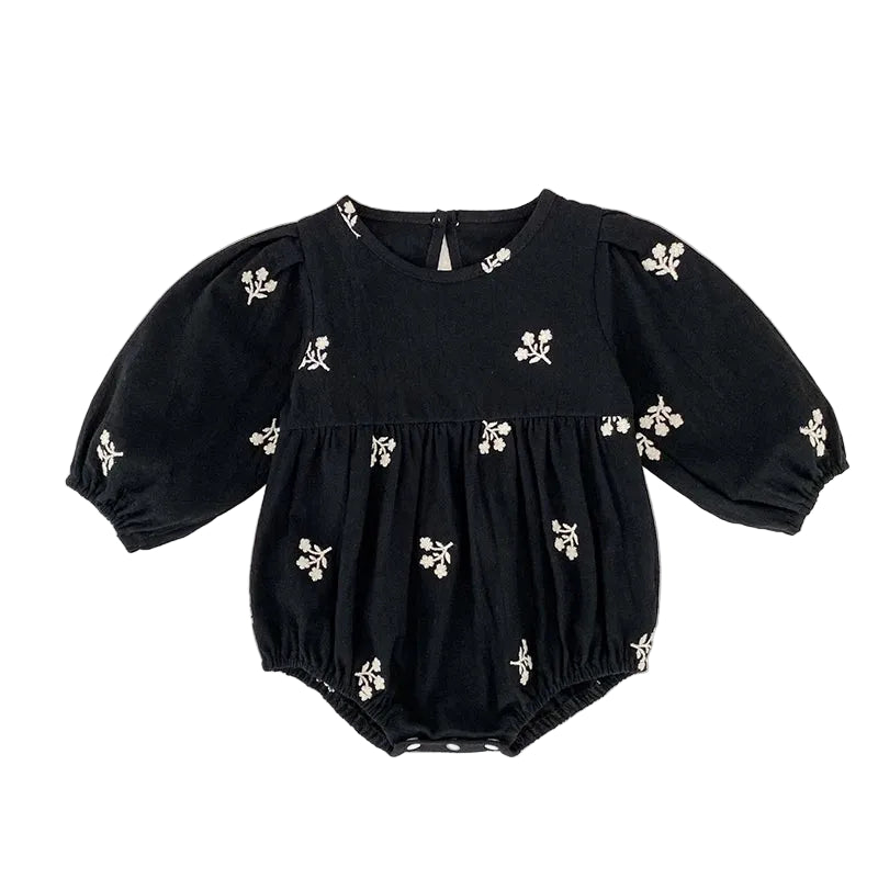 Front view of a baby girls black bubble romper featuring white floral embroidery and long puff sleeves.