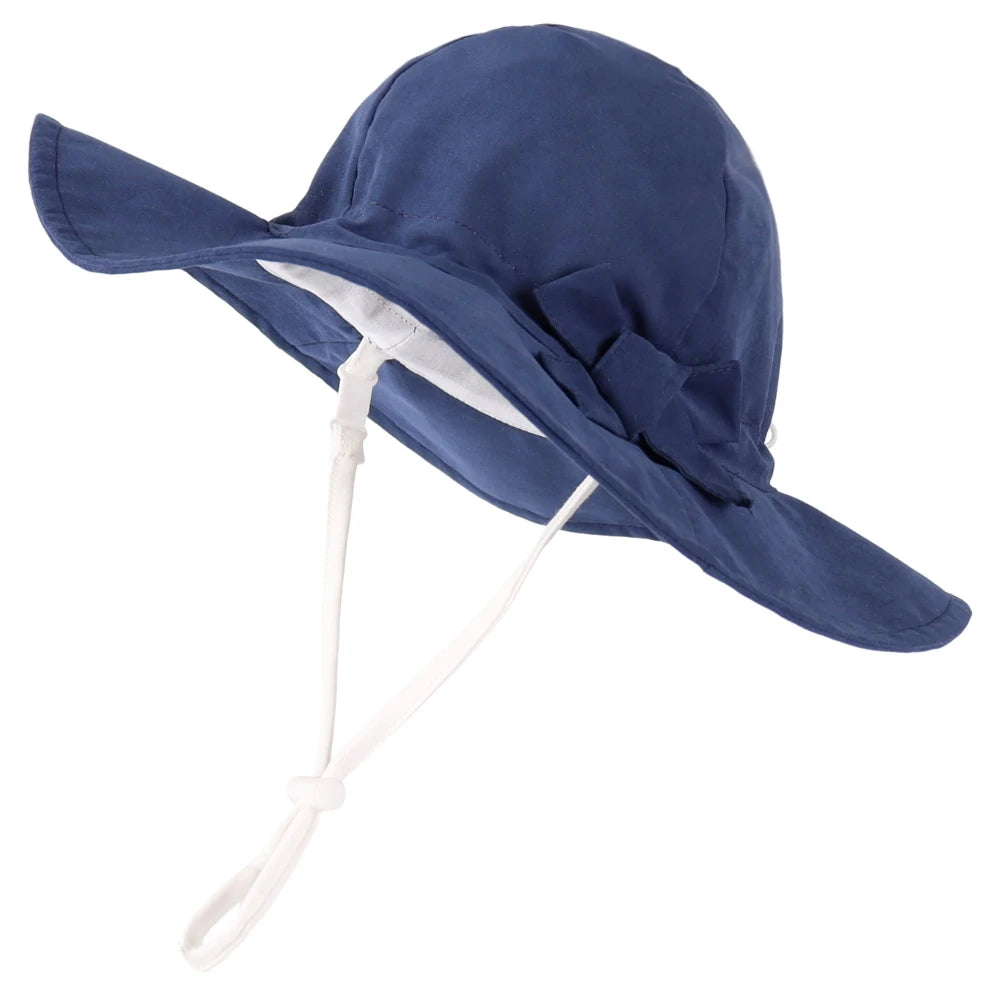 Dark navy blue 100% cotton wide brim sun hat for baby and toddler girls featuring an adjustable safety chin strap and matching bow.