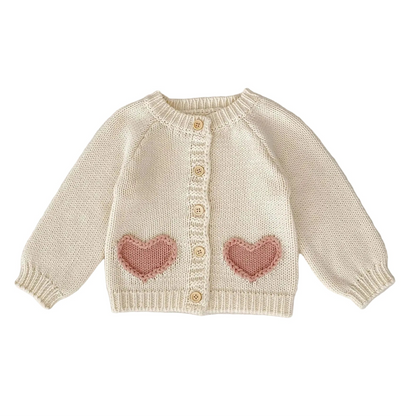 Cream knitted cardigan sweater for baby girls with pink heart pockets and front buttons.