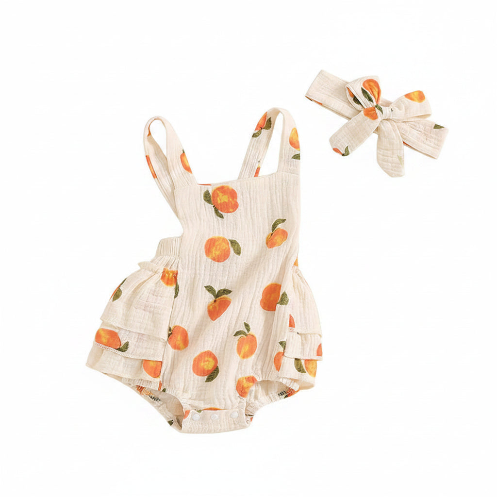 Side angle view of the sleeveless peach print baby jumpsuit showing the ruffles and side silhouette.