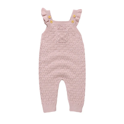Baby girls light pink chunky knit sleeveless romper overalls with ruffle straps and a front pocket, laying flat on a white background.