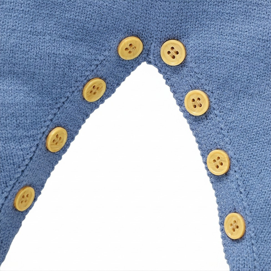 Close-up of the convenient wooden snap button closures along the leg inseam of the baby knit jumpsuit for easy diaper changes.