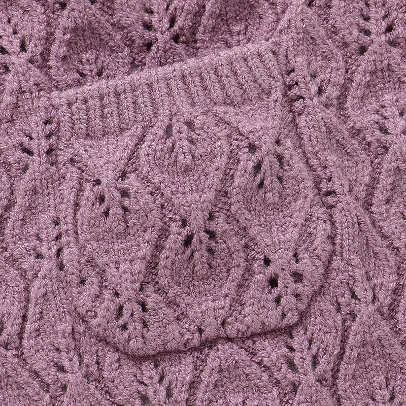 Close-up of the delicate pointelle knit pattern and center front pocket on a mauve baby sweater romper.