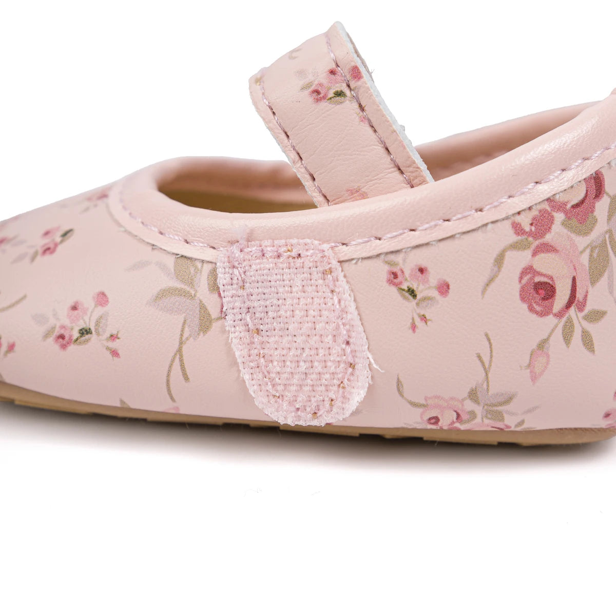 Side view of pink cottagecore infant shoes showing the adjustable strap closure.