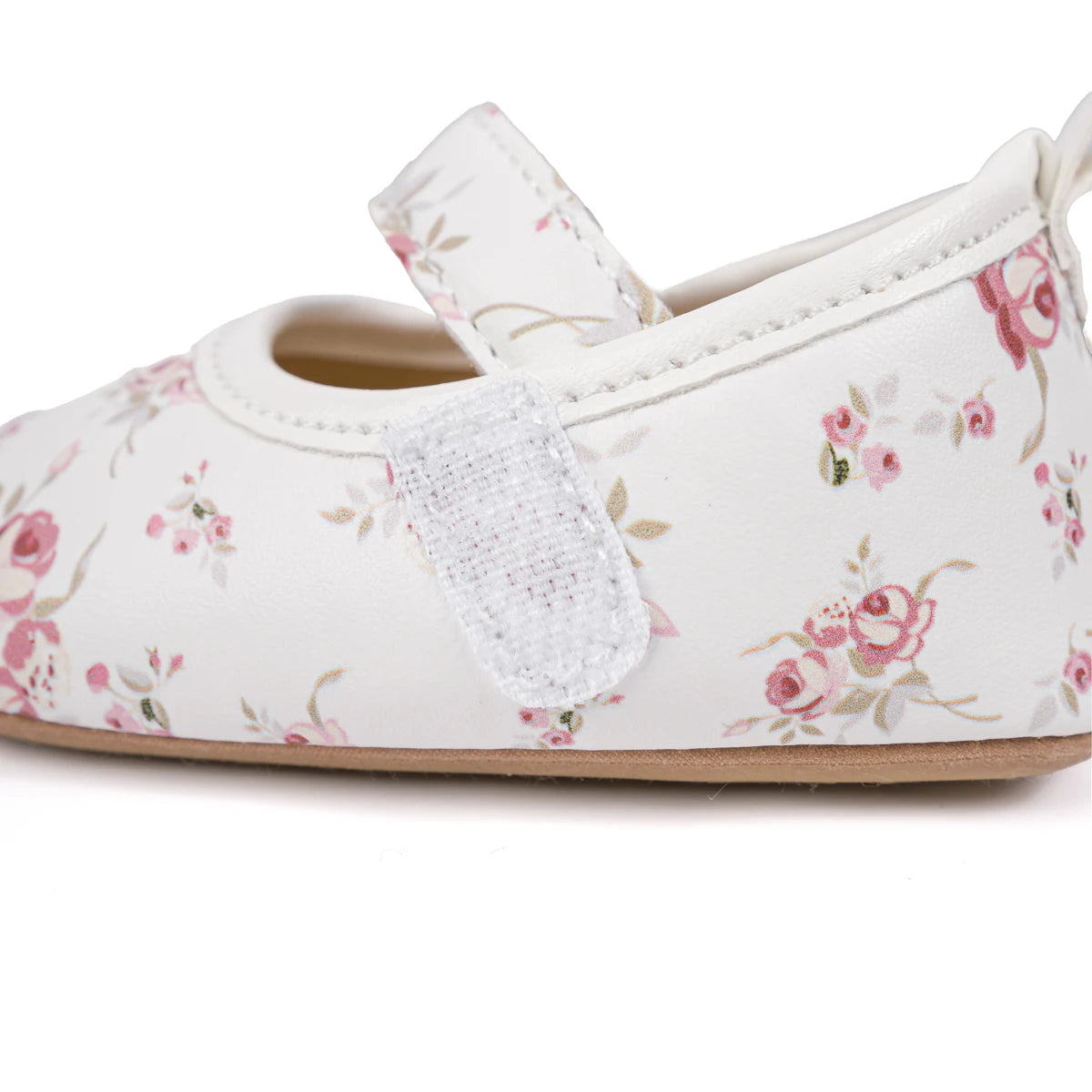 Side profile of white baby Mary Janes highlighting the secure hook-and-loop velcro strap.