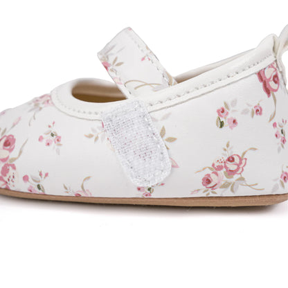 Side profile of white baby Mary Janes highlighting the secure hook-and-loop velcro strap.