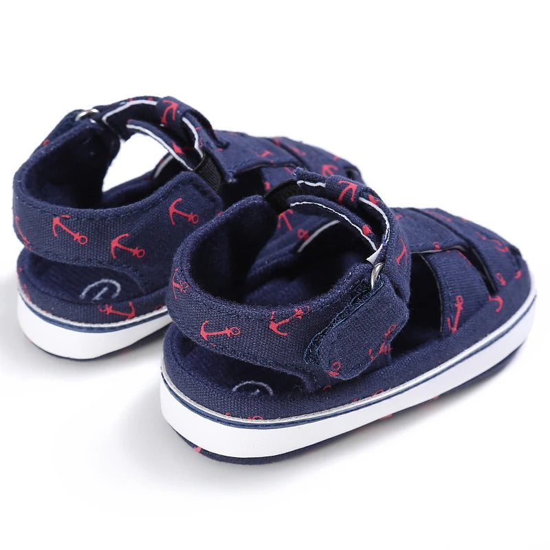 Back heel view of navy blue anchor print baby canvas summer sandals showing the enclosed heel support.