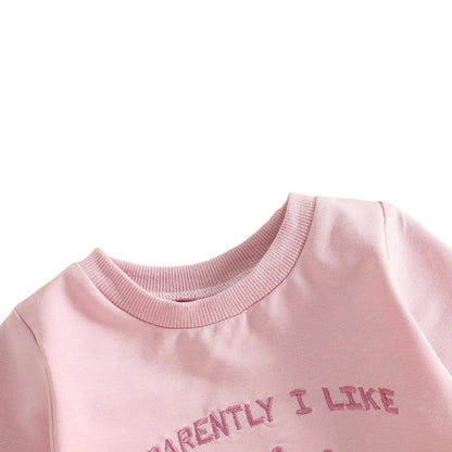 Close-up showing the soft ribbed crew neckline on the baby girl pink long-sleeve golf romper.