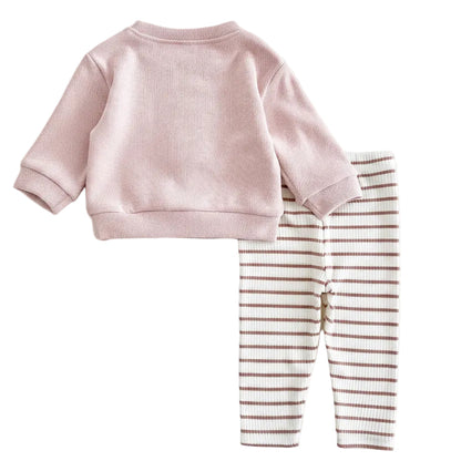 Flat lay product image showcasing the clean back view of the pastel pink crewneck pullover and the full striped print of the ribbed cotton-blend infant pants.