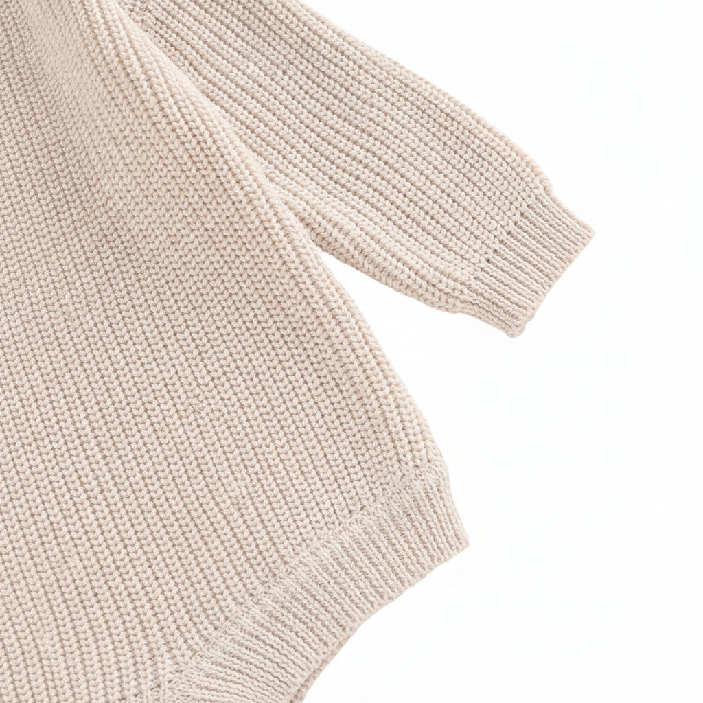 Close-up of the long sleeve cuff and smooth shoulder seam construction on the soft cotton blend knit romper.