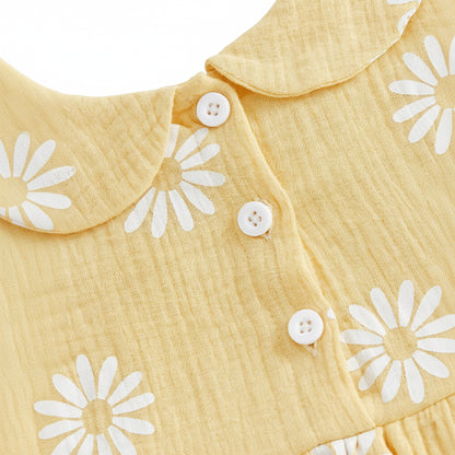 Close-up of the functional white button closures on the back of the yellow daisy print baby girl romper dress.