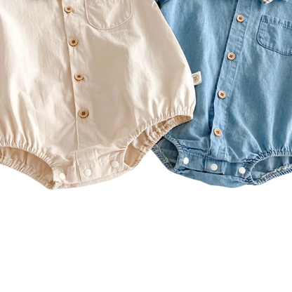 Detail shot of the off-white and blue rompers showing the reinforced snap closures for easy diaper changes.