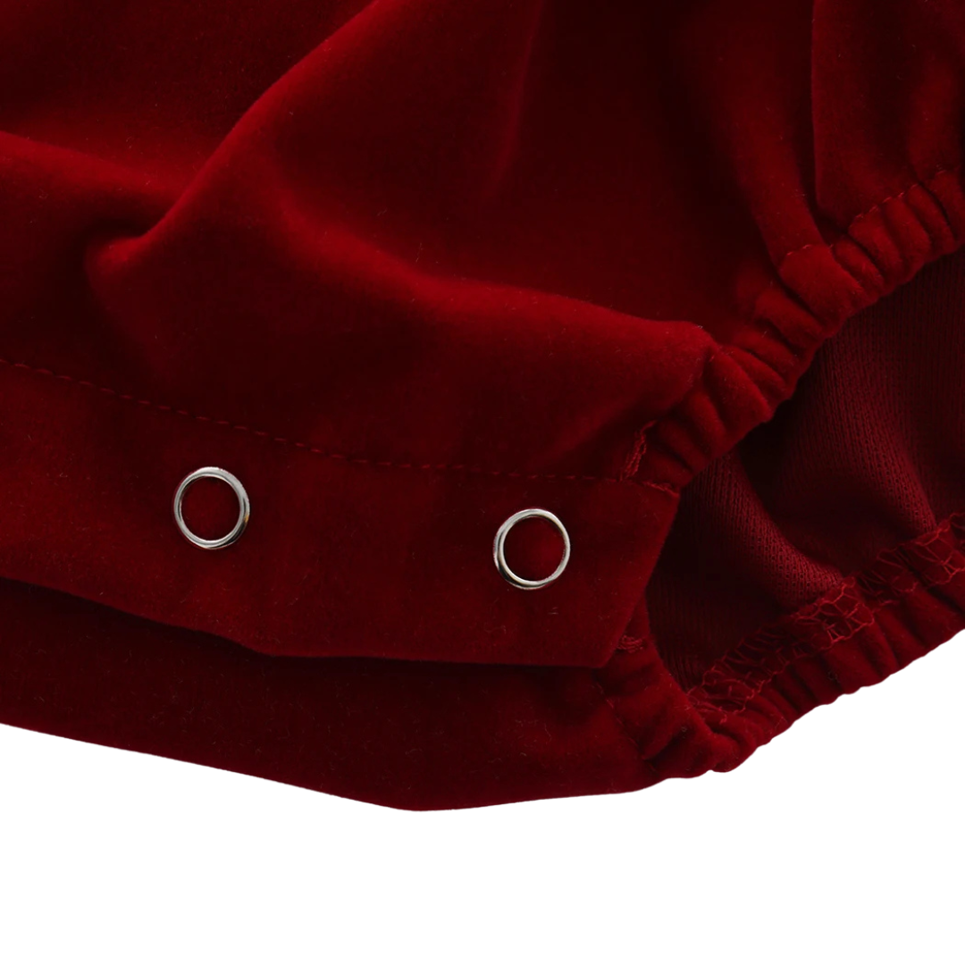 Close-up showing the securely closed metal snaps on the bottom of the red microfiber baby jumpsuit.
