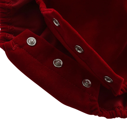 Close-up showing the open metal snap closures at the bottom crotch of the red baby romper for easy diaper changes.